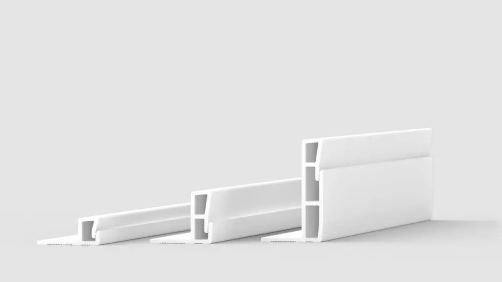 Three white plastic extrusion profiles are arranged on a plain, light gray background. Each profile has a rectangular, hollow structure with different heights and thicknesses, positioned side by side in a diagonal row.