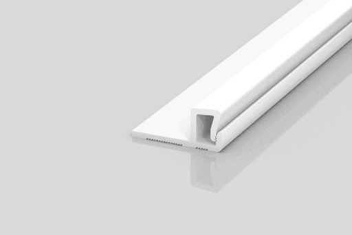 A white, rectangular plastic or metal trim piece with a U-shaped channel and a flat base, placed on a reflective light grey surface.