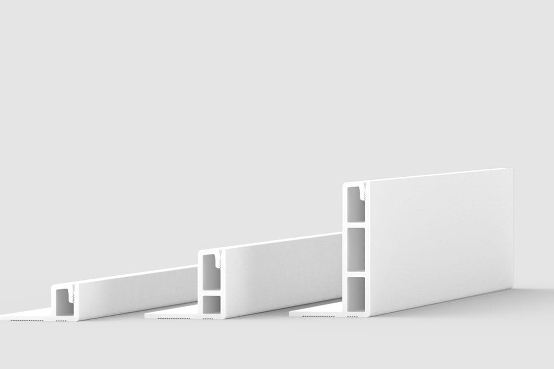 Three white, rectangular plastic profiles with hollow sections are shown standing upright on a reflective surface, positioned side by side, with increasing height from left to right