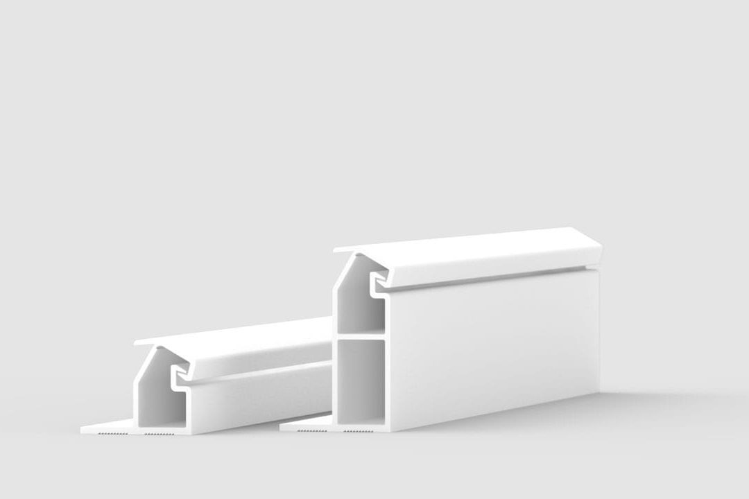 Two white, rectangular plastic extrusion profiles with hollow interiors and angled tops are displayed on a plain light gray background, with one profile larger than the other.