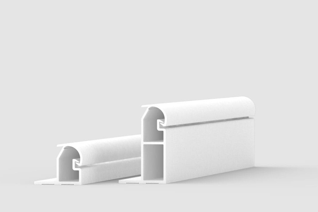 Two white, rectangular plastic or metal profile pieces with hollow interiors, standing upright on a plain light gray background. The pieces have rounded top edges and flat bases, with one profile larger than the other.