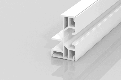 A white, extruded plastic or metal profile with multiple channels and angular sections, placed on a reflective, light gray surface. The profile appears to be a construction or architectural component.
